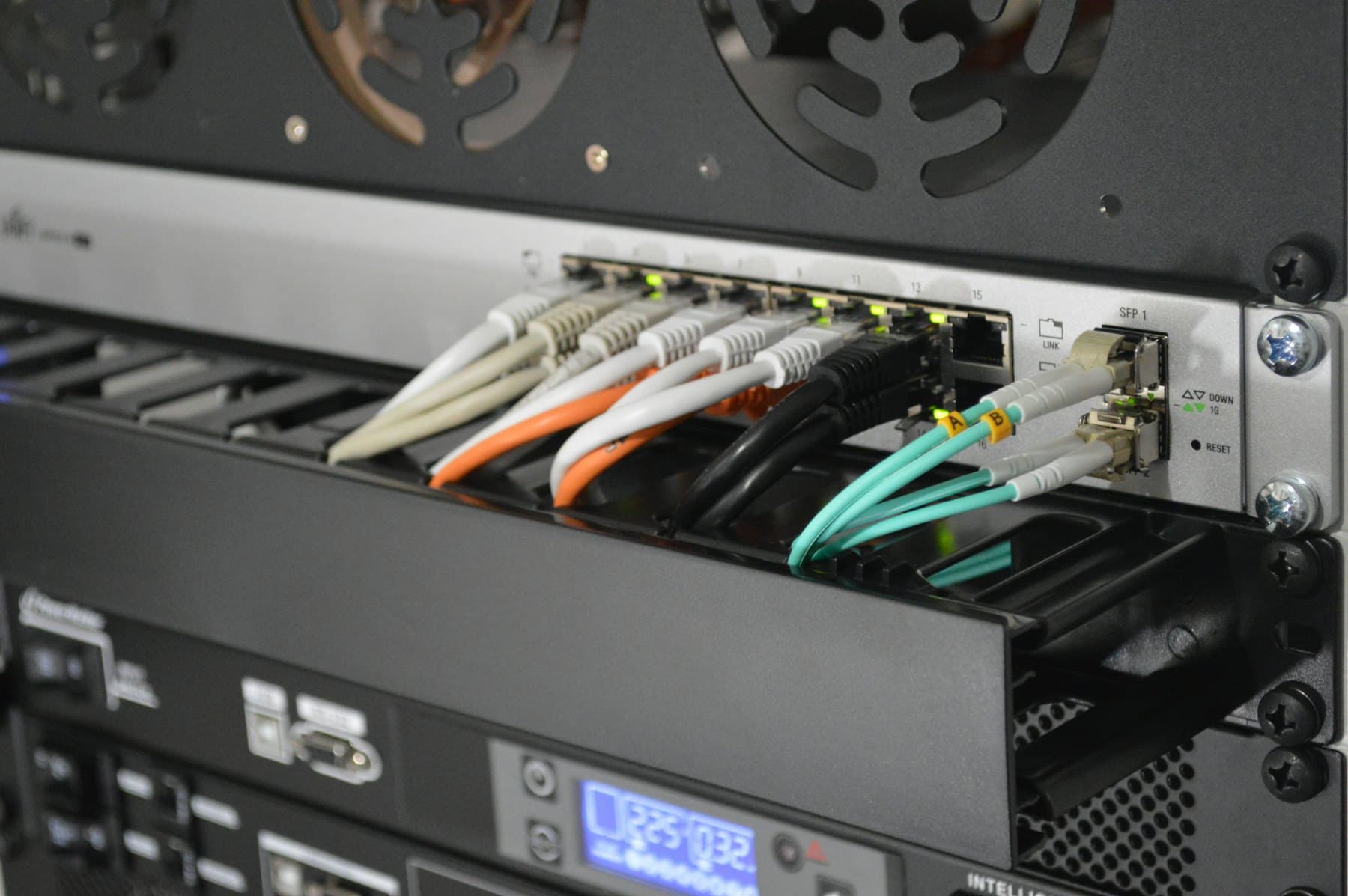 Network switch with fibre and copper patch cables connected to its ports